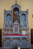 <center> Saint-Tropez. L'église Notre-Dame-de-l'Assomption </center> Autel de Saint Joseph et l'Enfant Jésus. Autel tombeau rectangulaire, dont la table repose sur des colonnettes, à l'avant. Le devant est orné, en bas-relief, de motifs végétaux. Un gradin puis un retable le surmontent. Carton-pierre : doré. Le saint esquisse un mouvement de marche avec sa jambe droite. Il tient l'Enfant, debout à côté de lui, par la main. 19e siècle.