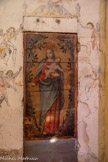 <center>Jouques.</center> Eglise Saint Pierre.  Vierge à l'Enfant. Peint sur un panneau (porte) de bois, 18e siècle, 1ère moitié 19e siècle. La Vierge debout tient de son bras gauche l'Enfant Jésus. La Vierge et l'Enfant tiennent chacun un chapelet et se trouvent dans un encadrement de verdure.