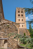 <center>L’abbaye de Saint-Michel de Cuxa</center>C'est à l'abbé Oliba avant 1046 que l'on doit attribuer la construction des deux clochers jumeaux, de style lombard, élevés aux extrémités des bras du transept. Il ne subsiste plus aujourd'hui que le clocher méridional. Il s'agit d'une tour haute de 33 mètres, décorée de bandes lombardes ; ses quatre étages sont percés de baies jumelées surmontées d'oculi. Des lesènes ou bandes saillantes verticales d'un seul jet sur trois étages soulignent l'élan vertical de cet endroit. La tour est couronnée par un crénelage, qui n'est pas d'origine. On lui rapporte un contrefort à la base vers le XVe siècle pour contrebalancer son inclinaison, qui aurait pu causer son effondrement.