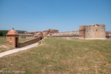 <center>Forteresse de Salses</center>L'innovation de Salses vient de la nécessité de s'adapter au développement de l'artillerie à boulet métallique. Les murailles, de six à dix mètres d'épaisseur, sont majoritairement constituées de moellons. À cette solide maçonnerie de moellons se mêlent des nombreuses parties constituées de briques pleines, la brique étant un matériau déjà connu à cette époque pour sa bonne résistance aux boulets. Le caractère le plus novateur de Salses, à l'époque où il fut construit, est que l'ensemble de la forteresse est semi-enterré au fond des profonds et larges fossés qui l'entourent. Seule dépasse du paysage environnant la moitié supérieure des tours et des courtines, le reste étant dissimulé aux yeux de l'assaillant.