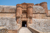 <center>Forteresse de Salses</center>Le châtelet est purement ornemental et n'est extérieurement pourvu d'aucun moyen défensif. Deux tourelles cylindriques en briques pleines catalanes ménagent une terrasse au-dessus d'une porte à fronton. Les tourelles encadrent un bas-relief en pierre qui est en léger retrait sous un arc en anse de panier. Le bas relief est orné d'armes qui pourraient ou auraient pu être celles des Rois Catholiques. Ensuite, il faut passer par cette porte pour atteindre la place d'arme après avoir parcouru un dédale de portes, de vestibules, de couloirs qui sont autant de pièges pour les attaquants.