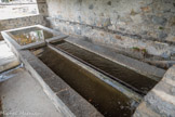 <center>La Tour-sur-Tinée. </center>Le lavoir. À l'intérieur, deux bassins de lavage accolés dans la longueur et un bassin de rinçage en enfilade. L'eau, qui provient du canal d'arrivée alimentant également le moulin à huile et un abreuvoir, passe dans trois conduites, celle du centre se prolongeant par une rigole jusqu'au bassin de rinçage.