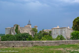 <center> Lussan.</center> Du parapet qui surmonte l’ancien rempart, nous pouvons observer la façade ouest du château du XVe siècle et son campanile du XIXe siècle.