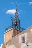 <center> Tavernes. </center> Le campanile de la tour de l‘horloge. Le soleil est ici symbolisé par le globe de laiton qui couronne le campanile. Les 6 piliers formant le socle de la structuré en fer forgé sont surmontés des 6 planètes. La cloche, datée de 1722, fut Classée Monument Historique en 1981. Contrairement à une dizaine de cloches du village, elle n'a pas été refondue à fa Révolution Française.