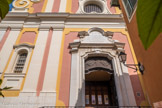 <center>Villefranche-sur-Mer. Église Saint-Michel </center> La porte principale s'inscrit dans une baie dont l'arc supérieur est légèrement cintré (une large courbe convexe flanquée aux encoignures de deux petites courbes concaves). Trois vantaux : deux battants de la porte et vantail supérieur fixe. Les trois sont décorés de panneaux rectangulaires ou polygonaux moulurés en bas-reliefs divisés chacun en pannonceaux entourant un petit bossage central ellipsoïdal ou carré.